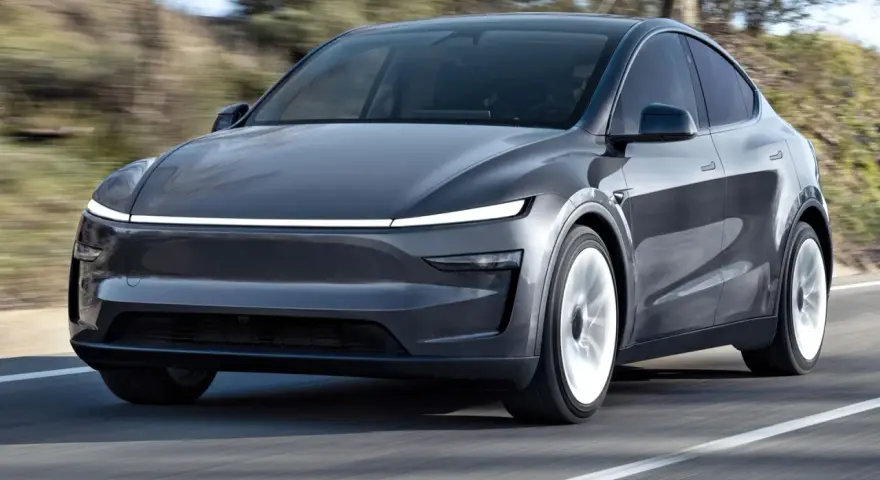 Szary Tesla Model Y w ruchu. Sprawdź aktualną tesla model y cena i możliwości tego elektrycznego SUV-a.