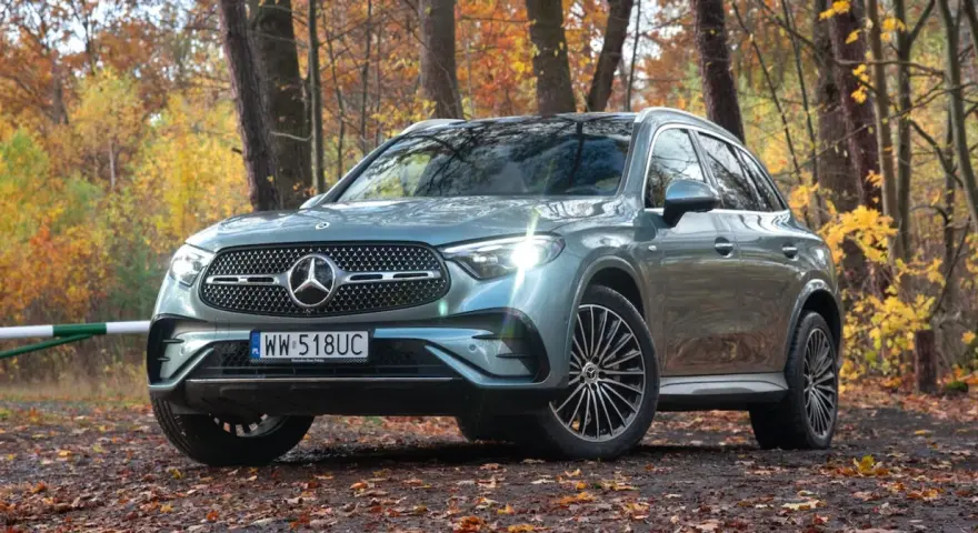 Elegancki Mercedes GLC 300 w jesiennym lesie, otoczony kolorowymi liśćmi.