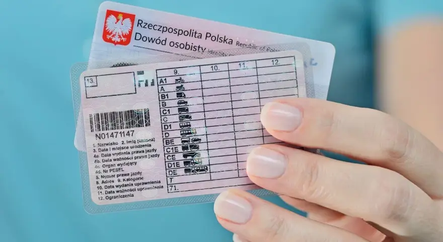 Dłoń trzyma polskie prawo jazdy z zaznaczoną kategorią B. Widoczny też dowód osobisty.