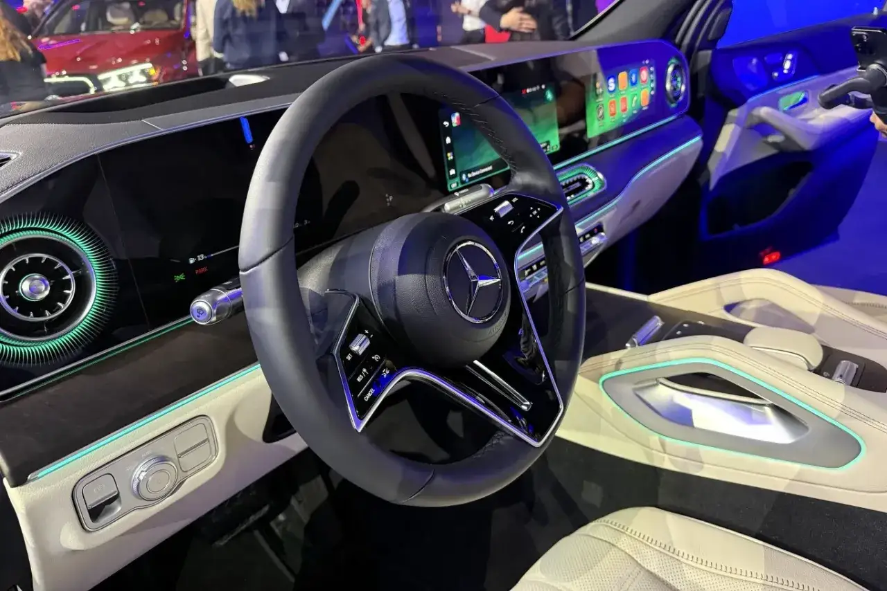 Wnętrze luksusowego Mercedesa GLS 580 z nowoczesnym kokpitem, dużymi ekranami i ambientowym oświetleniem.