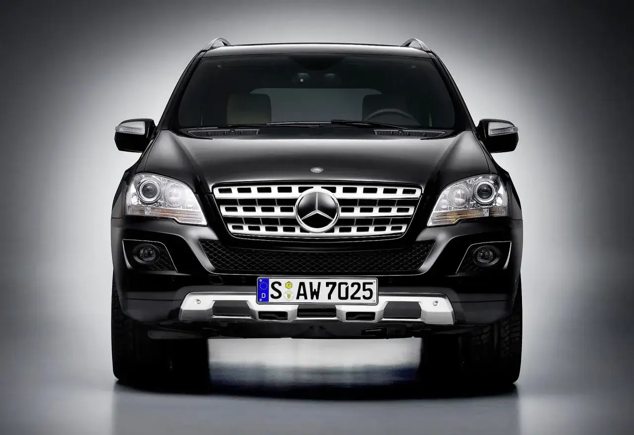 Czarny Mercedes ML 320 z chromowanym grillem i reflektorami.