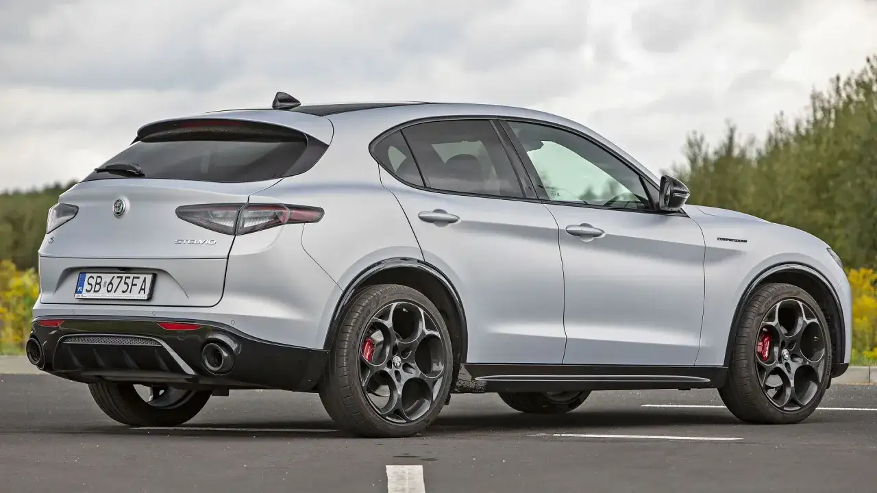 Srebrne Alfa Romeo Stelvio z czarnymi felgami i czerwonymi zaciskami hamulcowymi. Sprawdź aktualną alfa romeo stelvio cena i wyposażenie.
