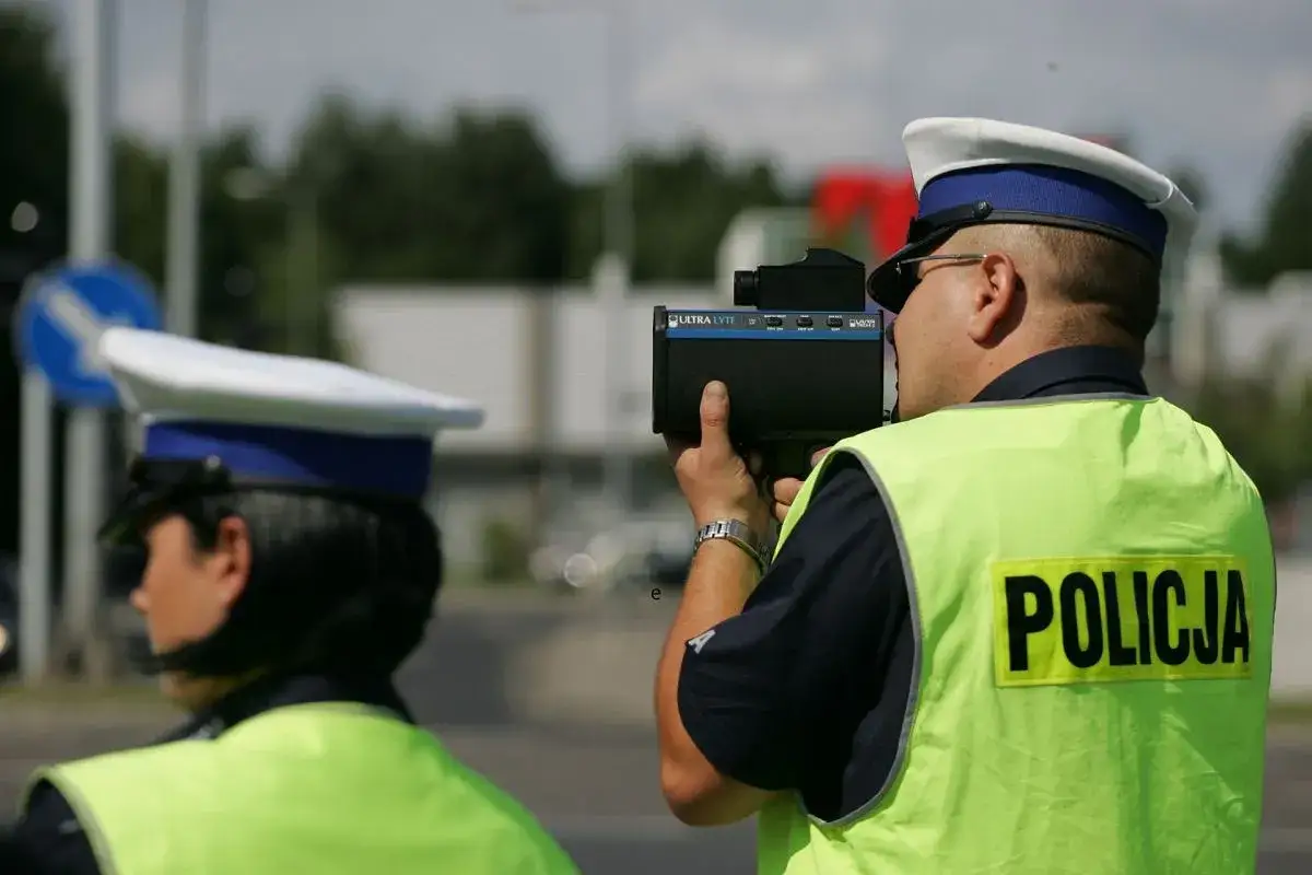 Policjant z radarem mierzy prędkość. Uważaj na drodze, bo grozi zatrzymanie prawa jazdy.
