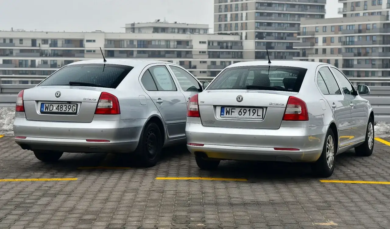 Dwa srebrne Skody Octavie na parkingu. Jedna z nich ma oznaczenie TSI, sugerujące silnik benzynowy, druga nie ma widocznego oznaczenia, co rodzi pytanie: diesel czy benzyna?