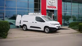 Biały, mały dostawczak z chłodnią na dachu stoi przed salonem Toyoty.